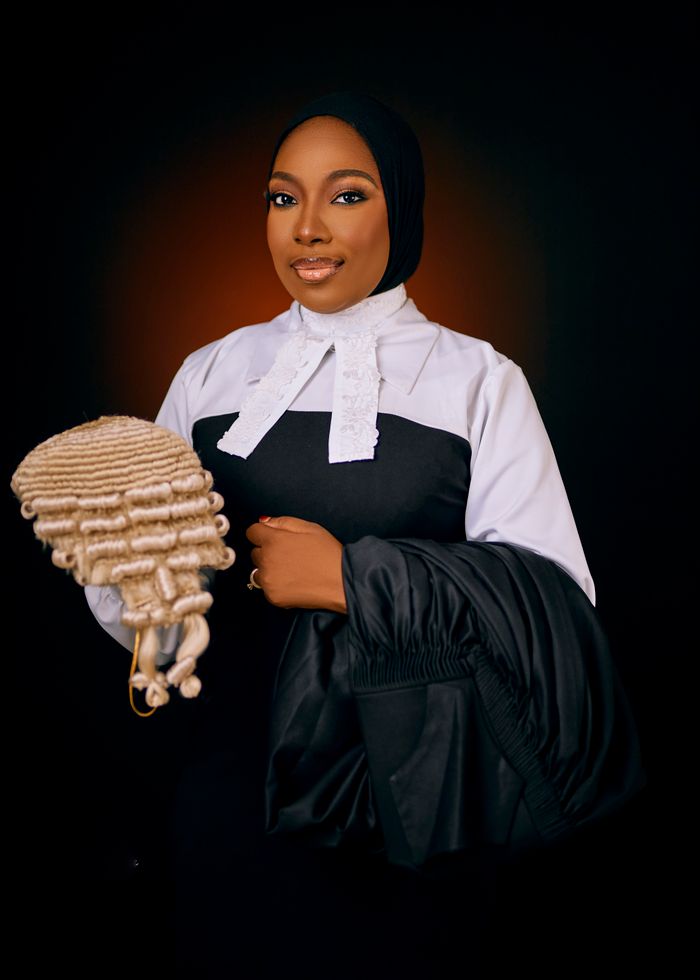 The Art of Drawing Readers In: Your attractive post title goes here Portrait of a poised female lawyer in courtroom attire holding a barrister wig against a dark backdrop.