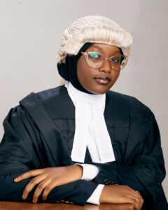 Portrait of a confident female lawyer wearing a wig and gown in a studio setting in Kano, Nigeria.